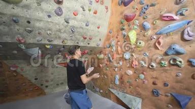 成年攀岩者正在攀岩健身房里攀岩。 男子在室内攀岩运动墙上锻炼